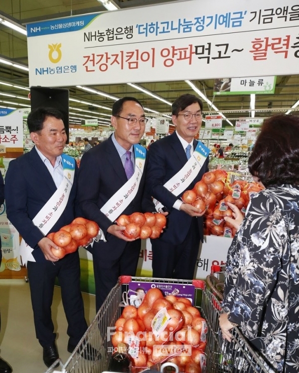 21일 오전 서울 서초구 하나로마트 양재점에서 열린 '양파 상생 마케팅 할인 행사'에서 이대훈 NH농협은행장(왼쪽 세번째)을 비롯한 참석자들이 할인판매하는 양파를 장 보러 온 시민의 카트에 담고 있다./사진=연합뉴스