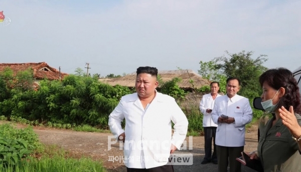 김정은 북한 국무위원장이 황해북도 은파군 대청리 수해현장에 직접 방문한 뒤 전시 등 유사시 사용하기 위해 비축한 전략물자와 식량을 풀어 수재민 지원에 쓰도록 지시했다고 7일 조선중앙TV가 보도했다. 김 위원장이 마스크를 쓴 여성 간부로부터 현장 설명을 듣고 있고, 뒤로는 조용원 당 조직지도부 제1부부장과 김용수 당 재정경리부 제1부부장으로 추정되는 인물 등이 대기하고 있다./사진=연합뉴스