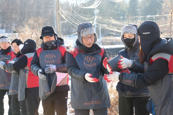 롯데건설 박현철 부회장(오른쪽 세번째)과 배우 정애리(오른쪽 두번째)가 임직원들과 함께 연탄을 나르고 있다. /사진=롯데건설