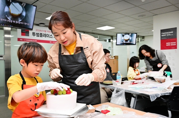 5월 15일(수), 가정의 달을 맞아 진행된 투썸플레이스 가족 초청 행사의 디저트 클래스에 참여한 임직원 자녀가 DIY 케이크 만들기에 집중하고 있다./사진=투썸플레이스