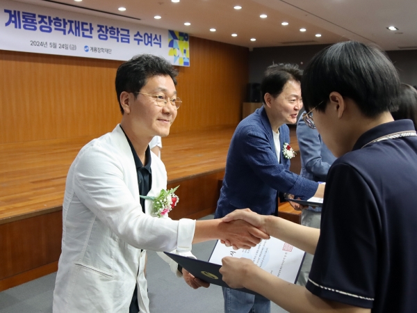 이승찬 계룡장학재단 이사장이 고등학생‧대학생에게 장학증서와 장학금을 전달하고 있다./사진=계룡그룹